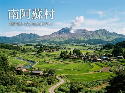 噴煙を上げる阿蘇山と緑豊かな棚田が広がる南阿蘇村の風景。