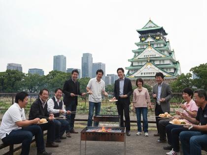 大阪城をバックにバーベキューを楽しむグループの写真