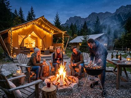 焚き火を囲んでBBQを楽しむグランピングのワンシーン