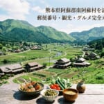 棚田と古民家が並ぶ日本の里山風景。手前に地元グルメ料理。